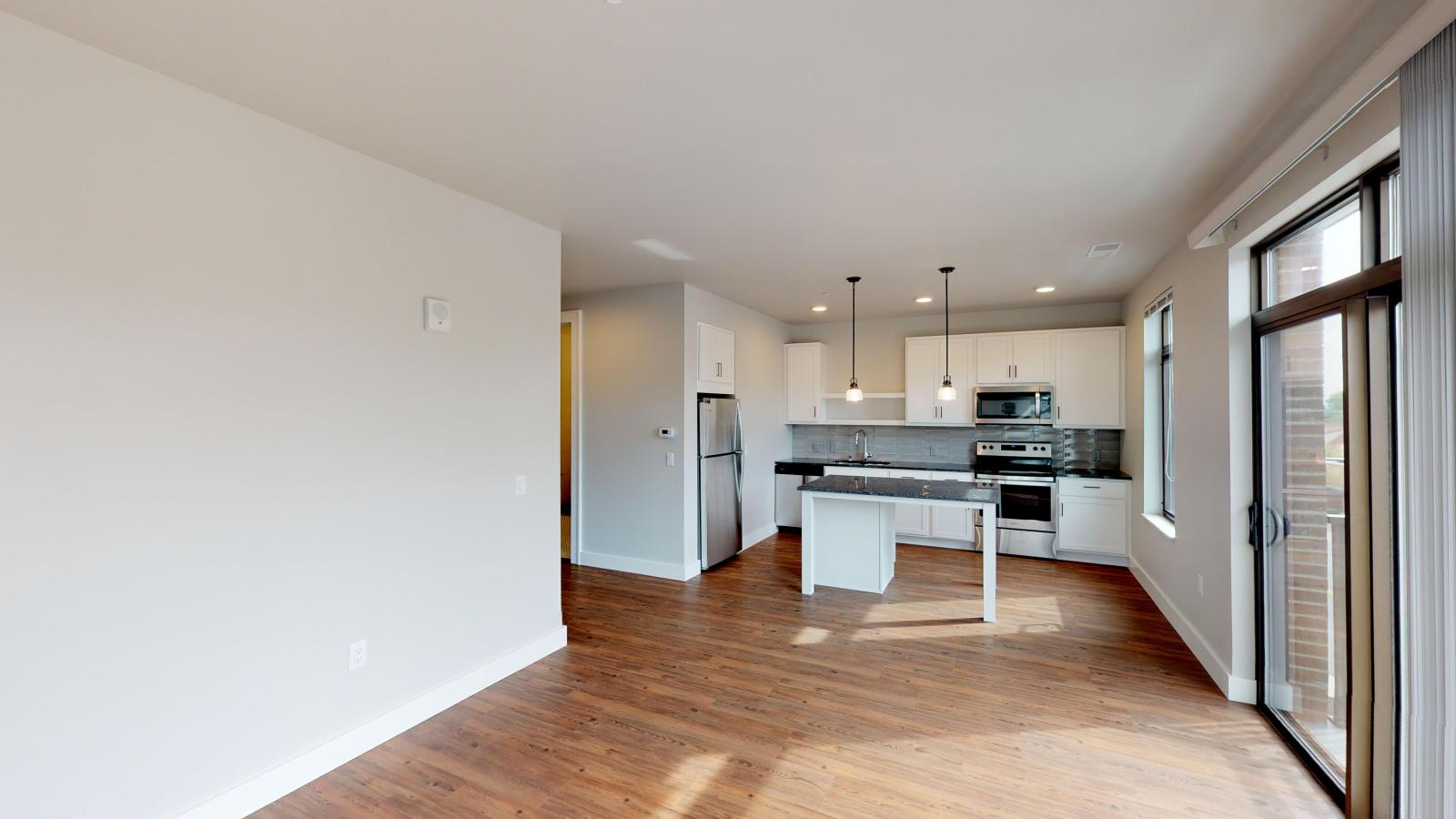 Modern kitchen in a 1722 Monroe apartment in Madison with white cabinetry, quartz countertops, and stainless steel appliances.