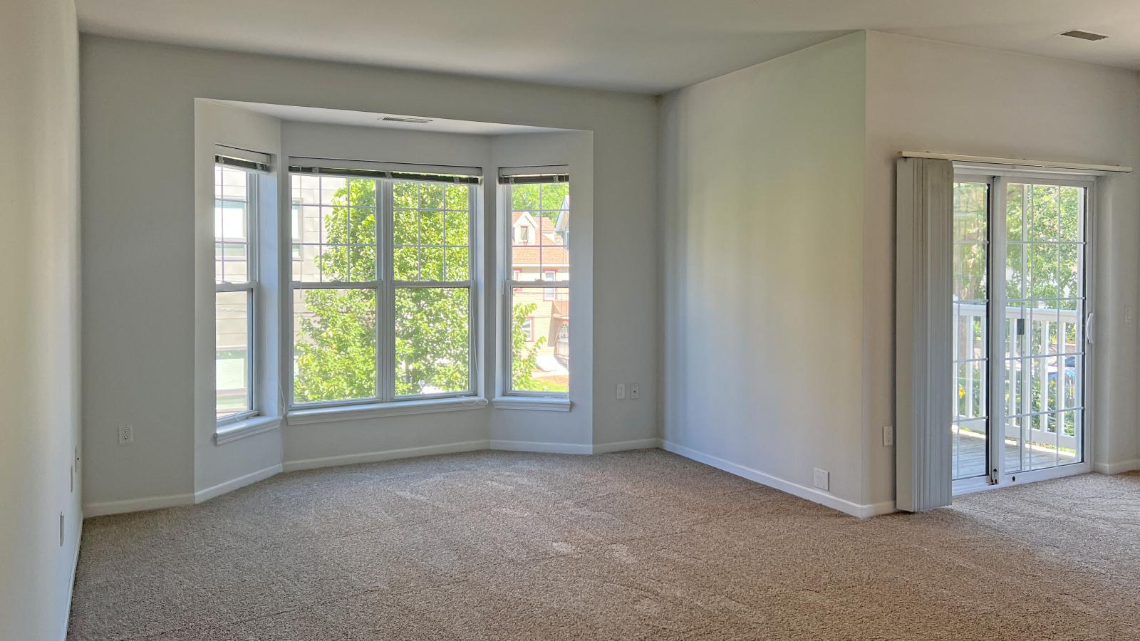 Living room with soft finishes, bay windows, and private balcony at City Place