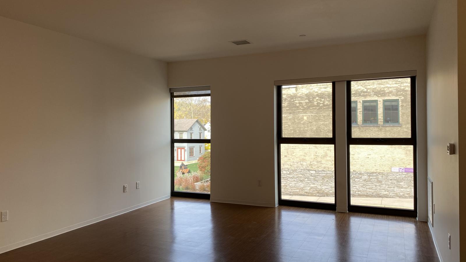 Spacious living room with Juliette balcony doors and natural light at SEVEN27