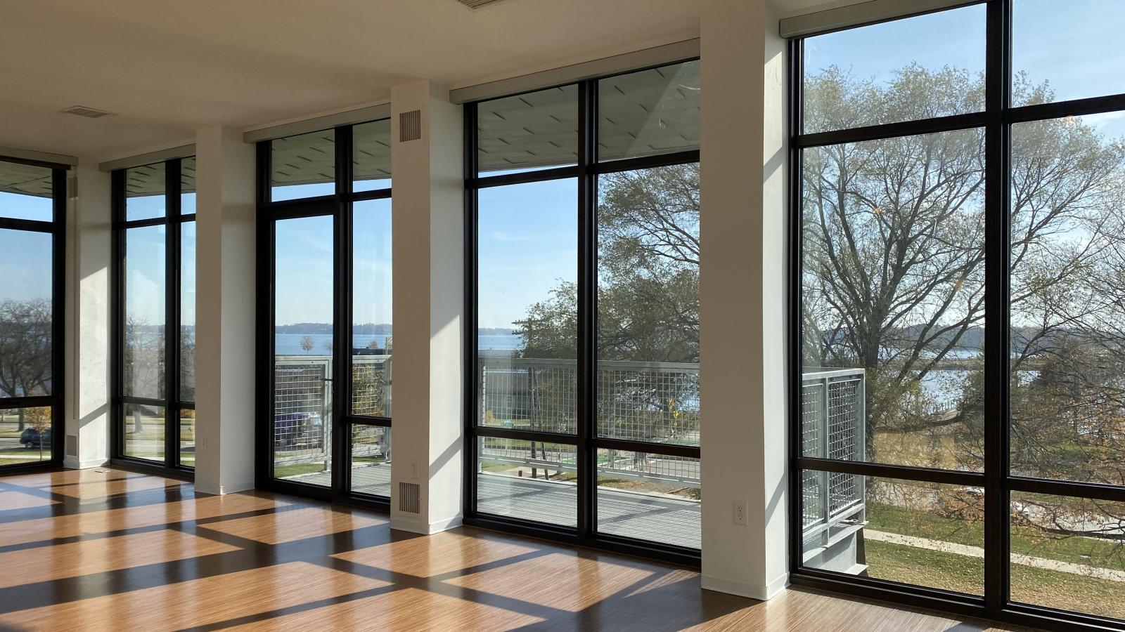 Spacious living room with floor to ceiling windows with lake view and expansive balcony at SEVEN27