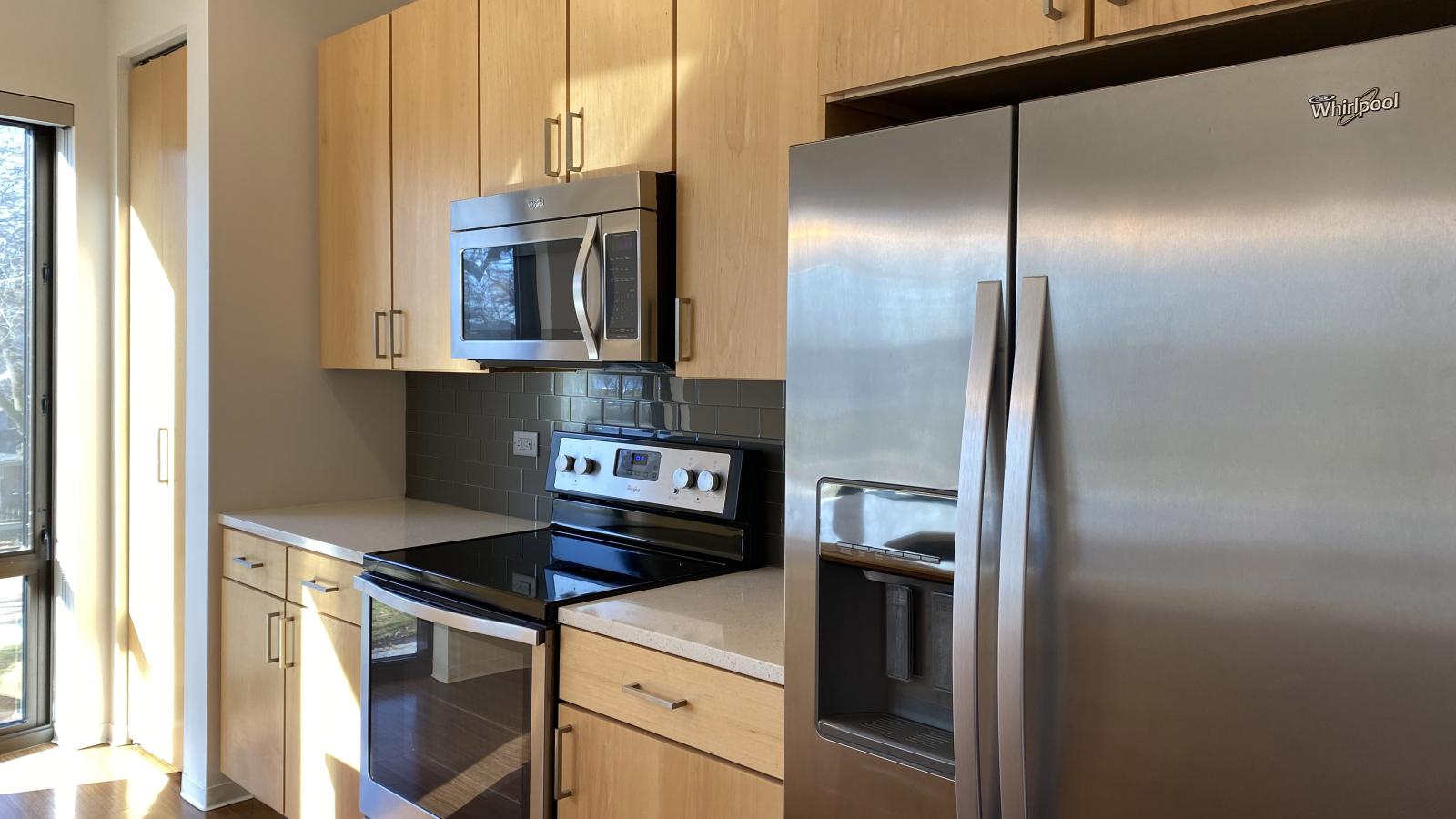 One bedroom apartment kitchen with quartz countertops and subway tile backsplash at SEVEN27