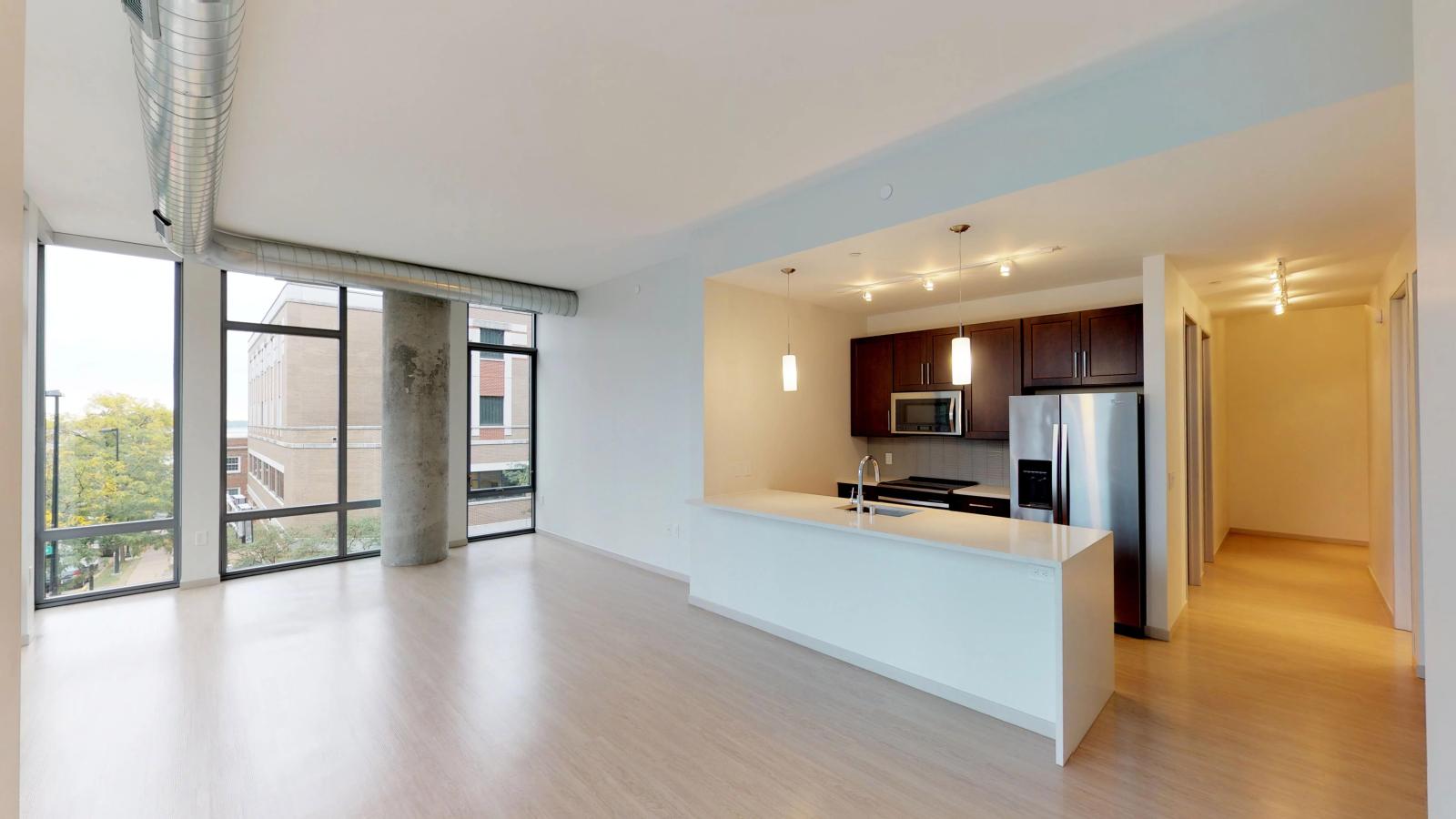 The Pressman two-bedroom apartment in downtown Madison featuring an open living space, high ceilings, and a modern kitchen.