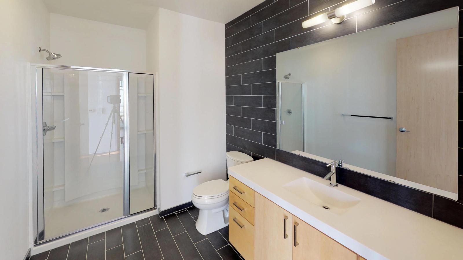 Bright bathroom with large mirror and stylish vanity at SEVEN27