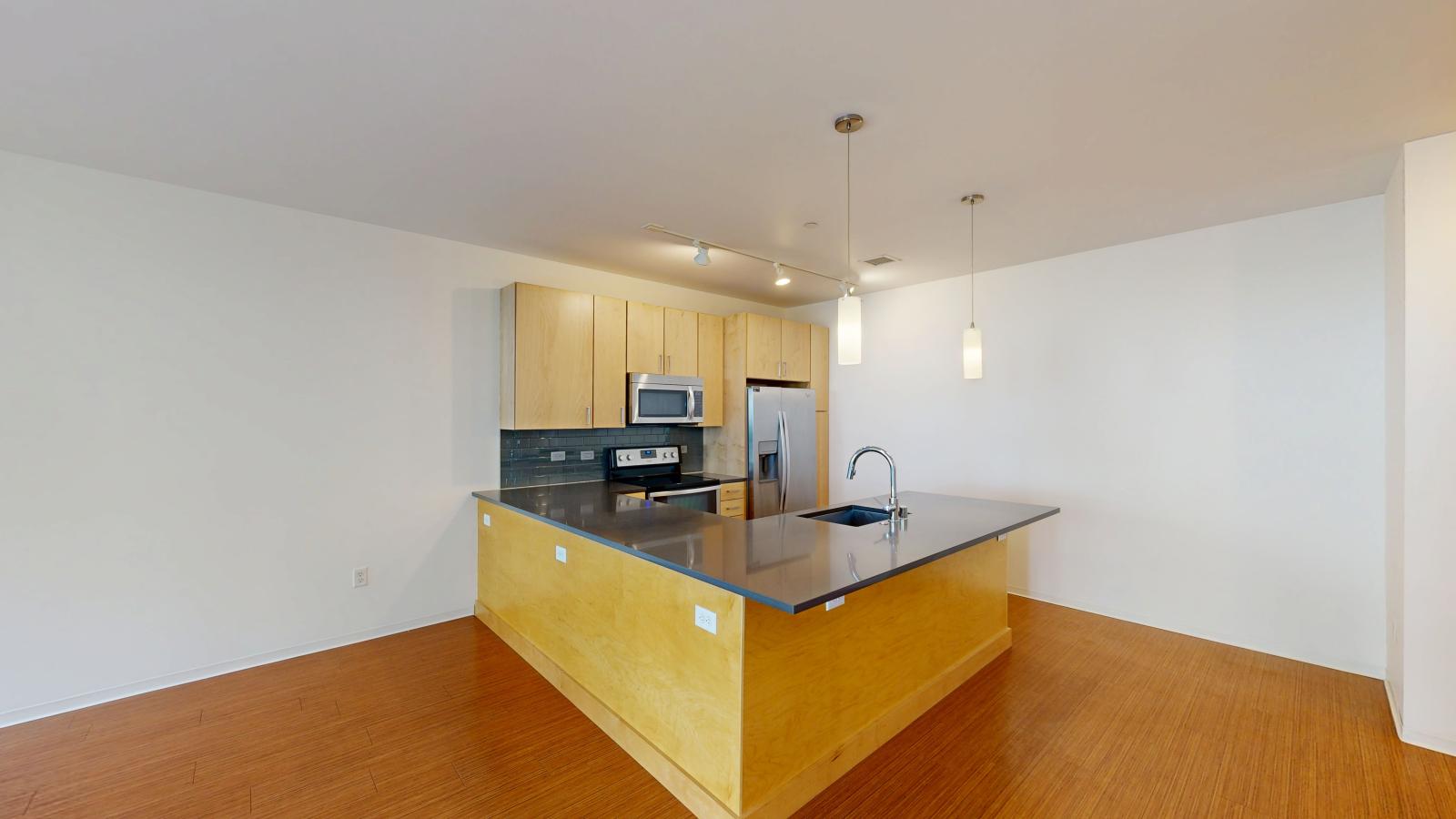 Luxury one bedroom apartment kitchen with quartz countertops and subway tile backsplash at SEVEN27 in downtown Madison
