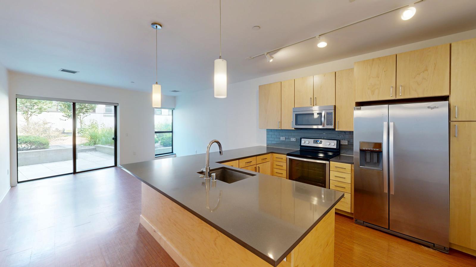 Luxury one bedroom apartment kitchen with quartz countertops and subway tile backsplash at SEVEN27 in downtown Madison