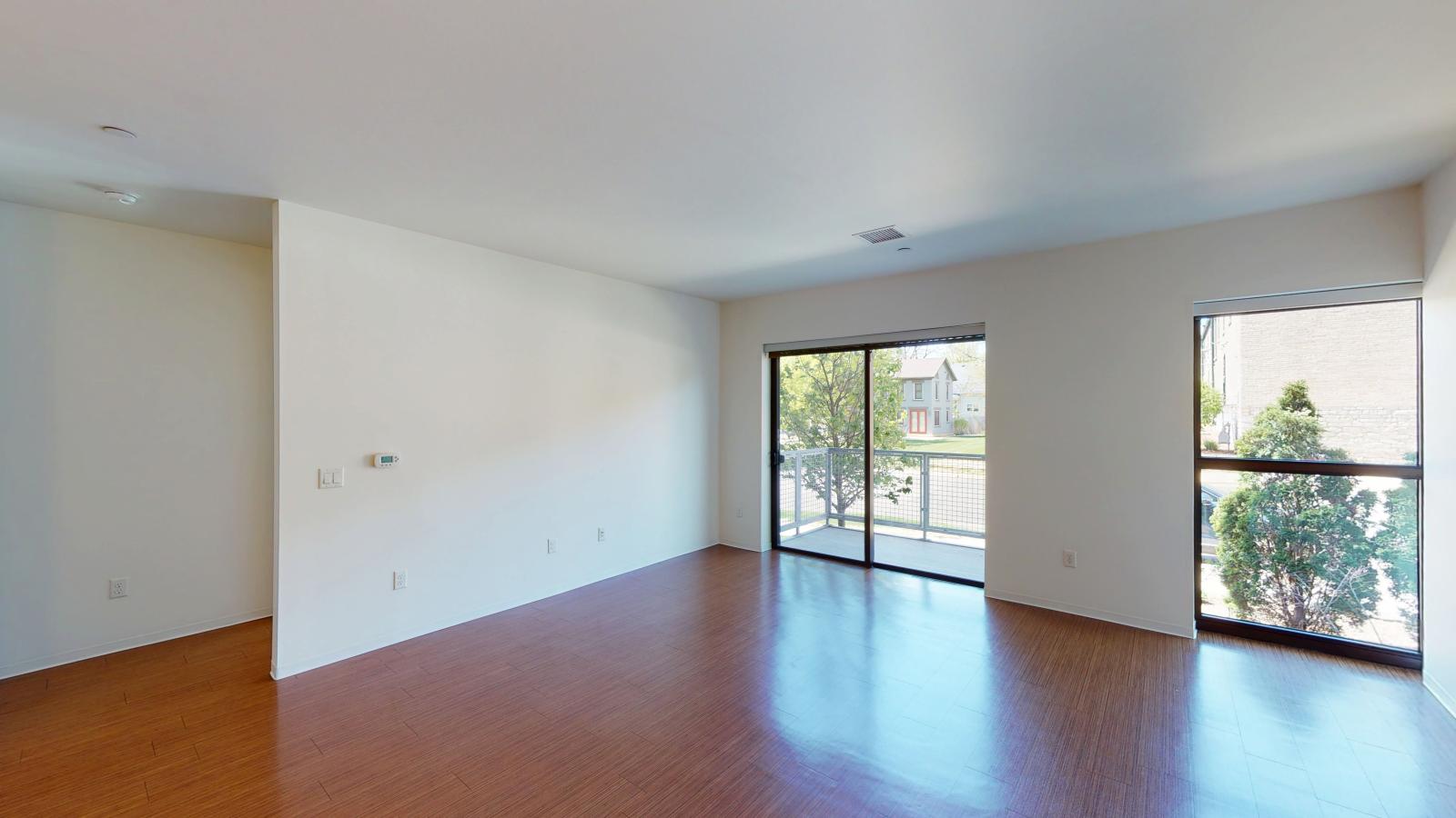 Spacious living room with Juliette balcony doors and natural light in a one bedroom apartment at SEVEN27 in downtown Madison