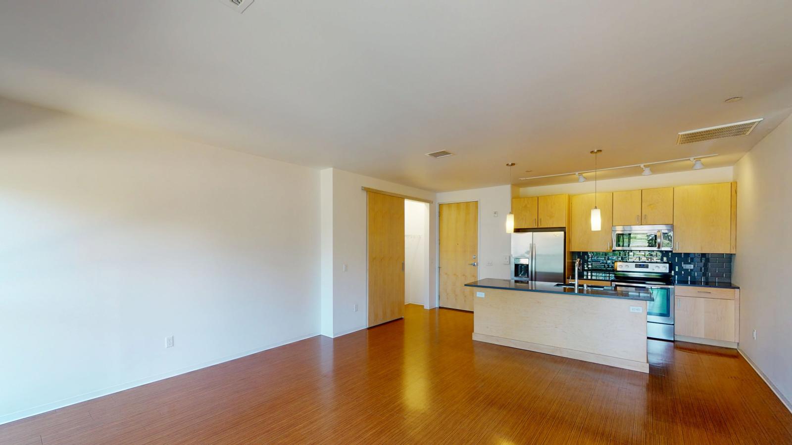 One bedroom with modern kitchen with quartz countertops and stainless steel appliances at SEVEN27 in downtown Madison