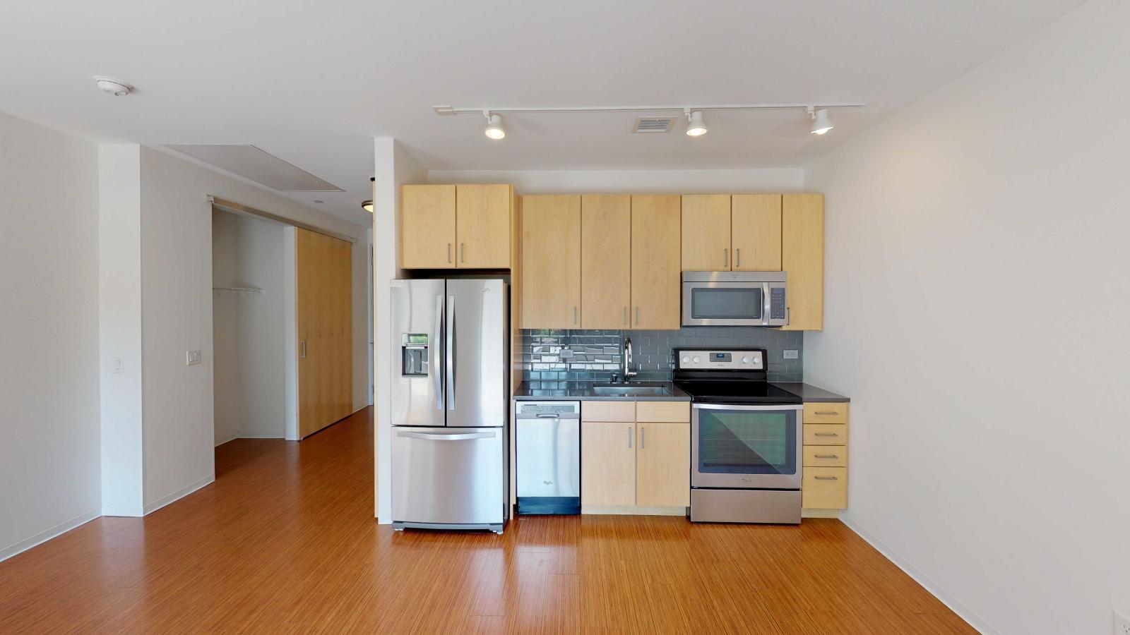 Studio apartment kitchen with open concept and stainless steel appliances at SEVEN27