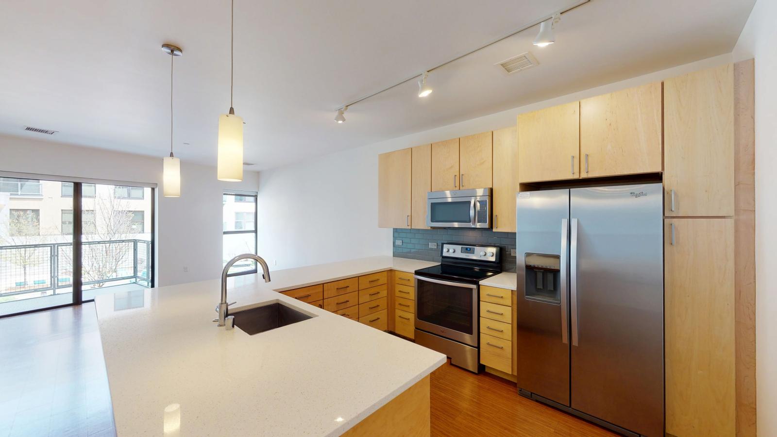 One bedroom apartment wrap around  kitchen with quartz countertops and subway tile backsplash at SEVEN27 in downtown Madison