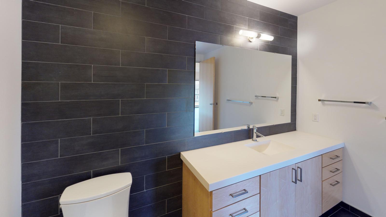 One bedroom apartment bathroom with spacious vanity and designer fixtures at SEVEN27