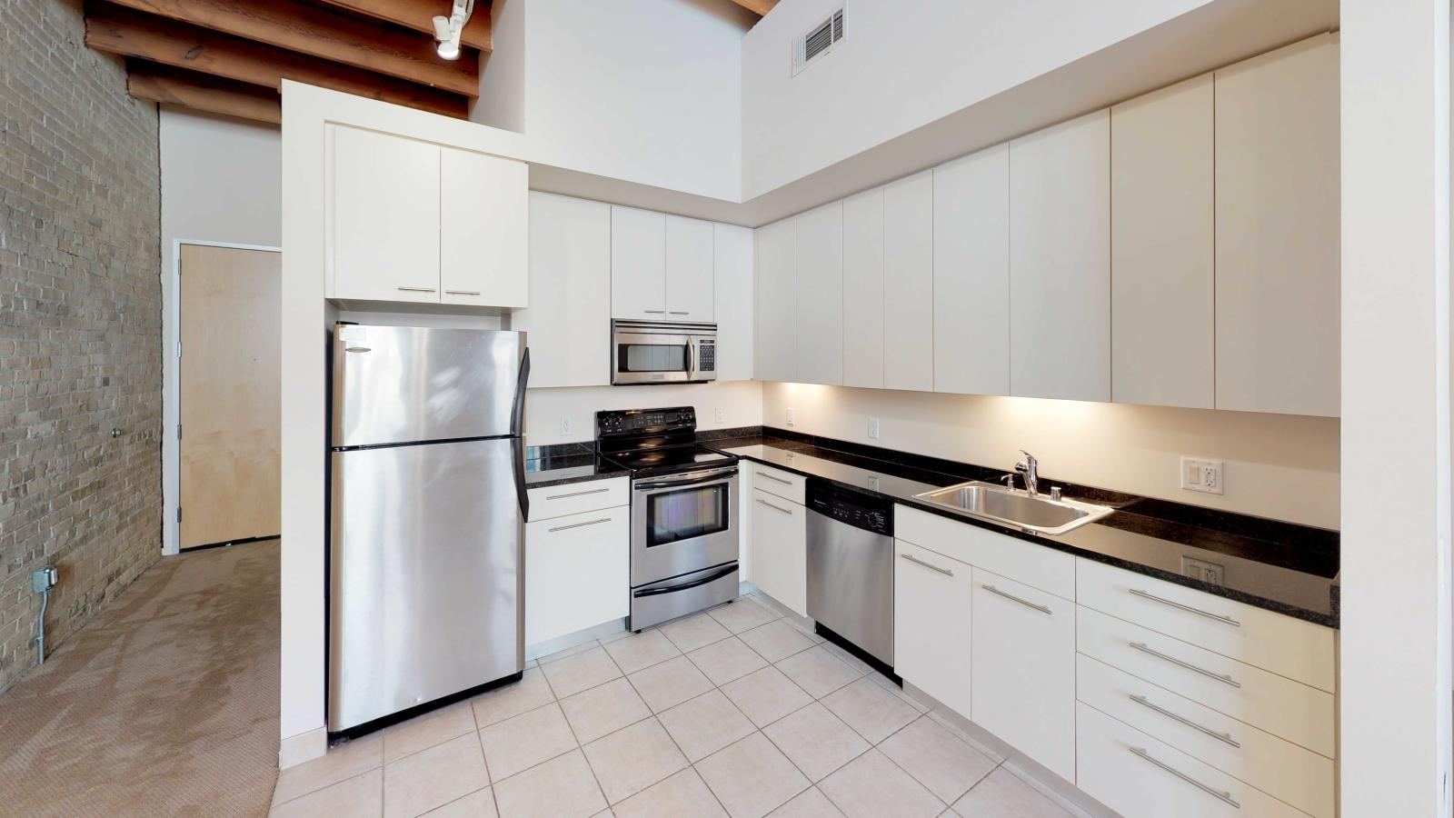 Studio apartment with stainless steel appliances and granite countertops at Tobacco Lofts